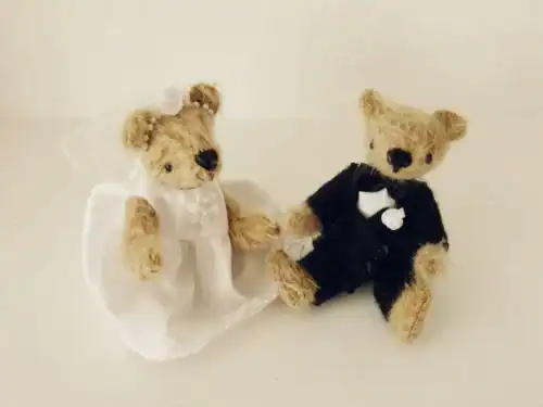 A bride and groom teddy bear set in their wedding outfits made from an upcycled wedding dress.