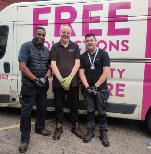Birmingham Hospice's House Clearance Team. Three men standing side-by-side, smiling in front of a van.